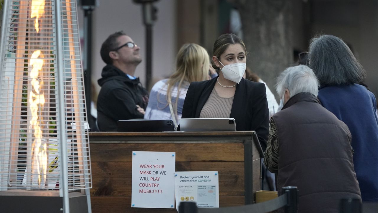 A hostess seats customers in an outdoor dining area amid the COVID-19 pandemic on The Promenade Wednesday, June 9, 2021, in Santa Monica, Calif. (AP Photo/Marcio Jose Sanchez)