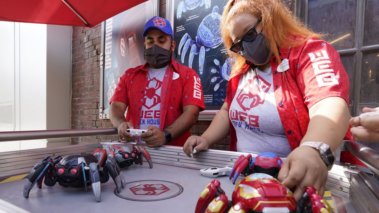 Cast Members Ryan Garcia, left, and Cristal Aros demonstrate Spider-Bots toys at the Avengers Campus media preview at Disney's California Adventure Park on Wednesday, June 2, 2021, in Anaheim, Calif. (AP Photo/Chris Pizzello)