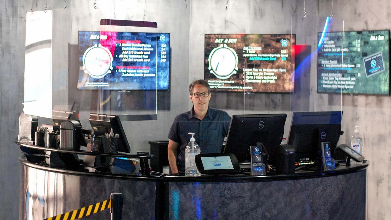man sitting behind a round desk at a laser tag arena