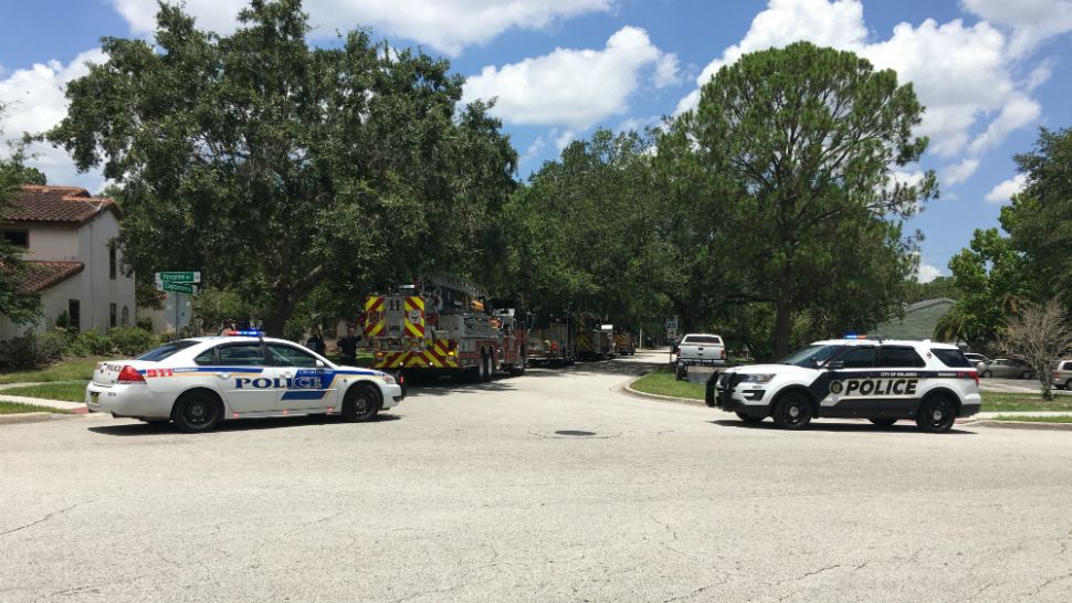 Orlando Police and firefighters surround an apartment building near Universal Orlando on Monday afternoon, where a man is reportedly is barricaded inside with 4 children. A police officer was shot there overnight. (Tony Rojek, staff)