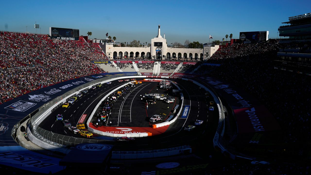 Competitors make a turn during a NASCAR exhibition auto race at Los Angeles Memorial Coliseum, Sunday, Feb. 6, 2022, in Los Angeles. (AP Photo/Marcio Jose Sanchez)
