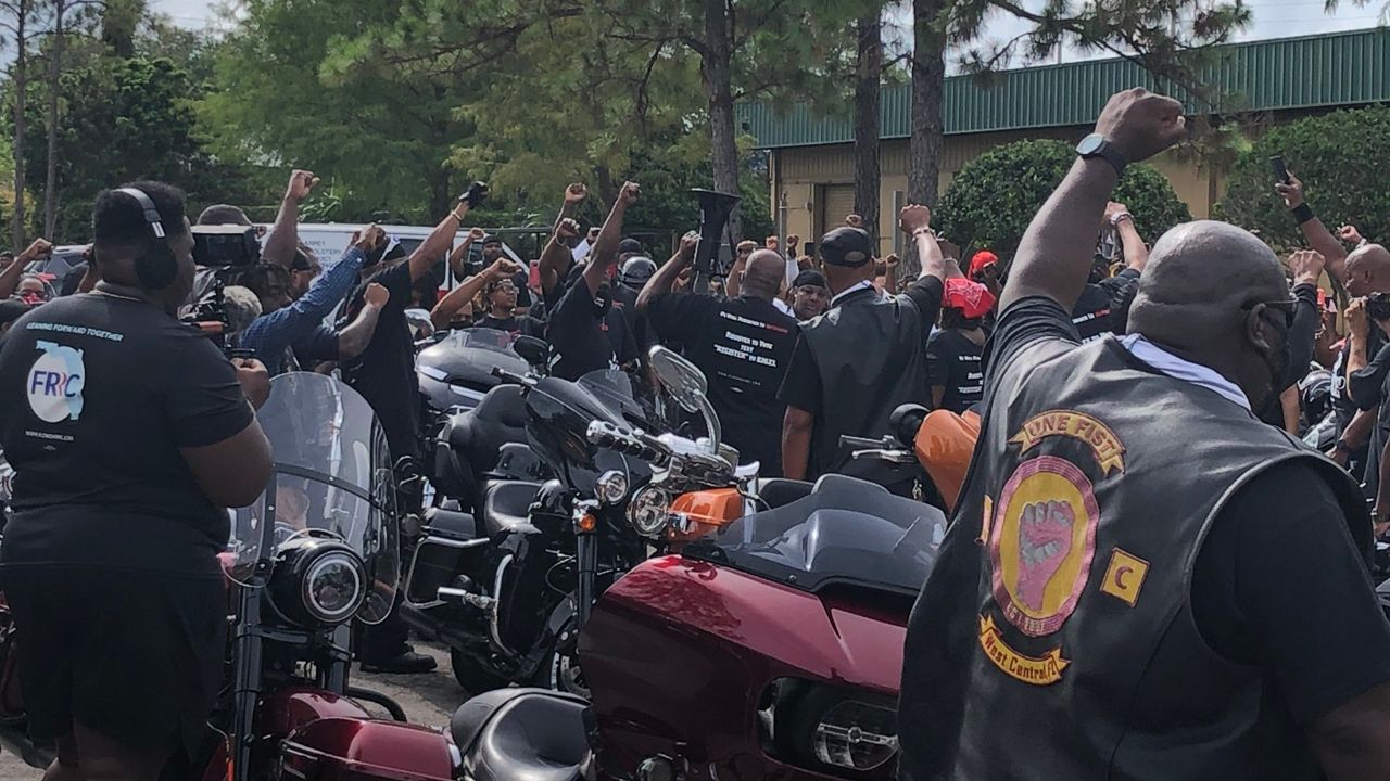 Bikers with the Ride for Justice pump their fists as part of a call for reform in Orlando Saturday. (Rachael Krause, Spectrum News)