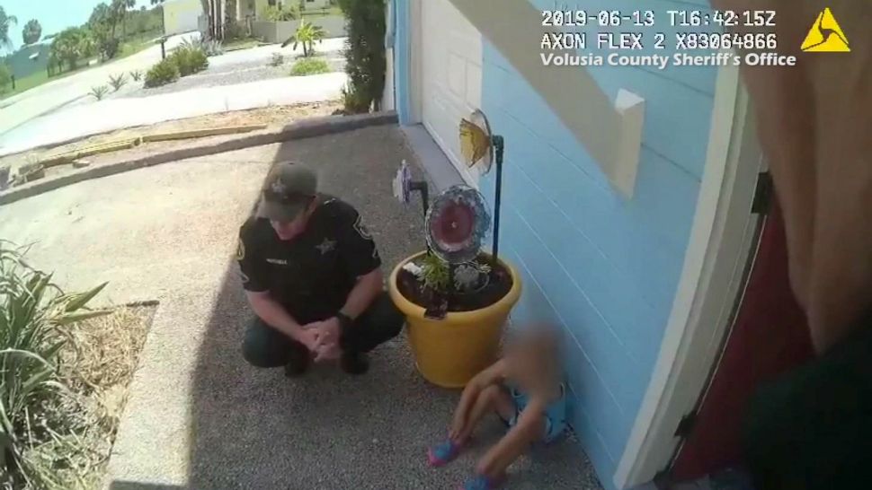 An image taken from a deputy's body-worn camera footage shows a deputy talking to a young girl. Investigators say she was accompanying a man who was breaking into homes and property Thursday. (Volusia County Sheriff's Office)