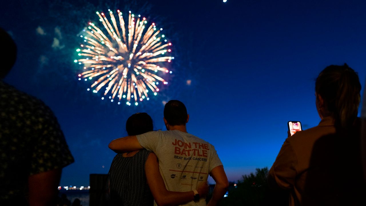 People watch as fireworks explode over New York Harbor on Tuesday, June 15, 2021 in New York. (AP File Photo/Craig Ruttle)