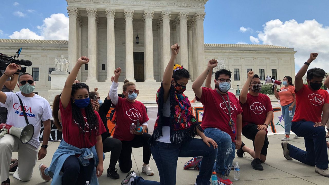 DACA activists take a knee and observe a moment of silence for those who have died in law enforcement custody Thursday morning in front of the U.S. Supreme Court in Washington. (Em Nguyen/Spectrum News)