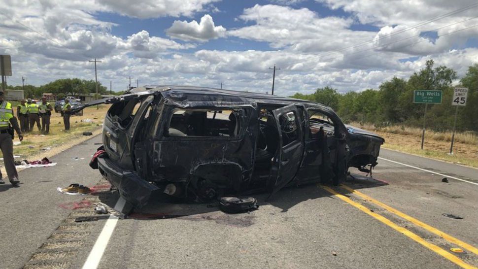 In this image tweeted by David Caltabiano of KABB/WOAI, a heavily damaged SUV is seen on Texas Highway 85 in Big Wells, Texas, after crashing while carrying more than a dozen people fleeing from Border Patrol agents, Sunday, June 17, 2018. (David Caltabiano/KABB/WOAI via AP)