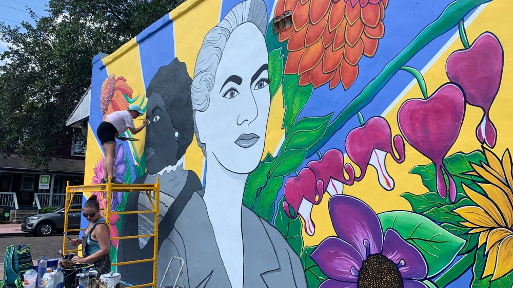Artists put the finishing touches on this mural of Dr. Mary McLeod Bethune and Beth Johnson, two leaders in the women's suffrage movement. (Christie Zizo, Spectrum News)