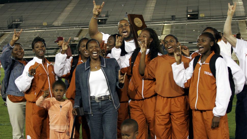 Members of the Texas women's team give the "hook 'em horns" sign after Texas won the women's team title at the NCAA track and field finals Saturday, June 11, 2005, in Sacramento, Calif. In front is coach Beverly Kearney, in jeans. (AP Photo/Dino Vournas)