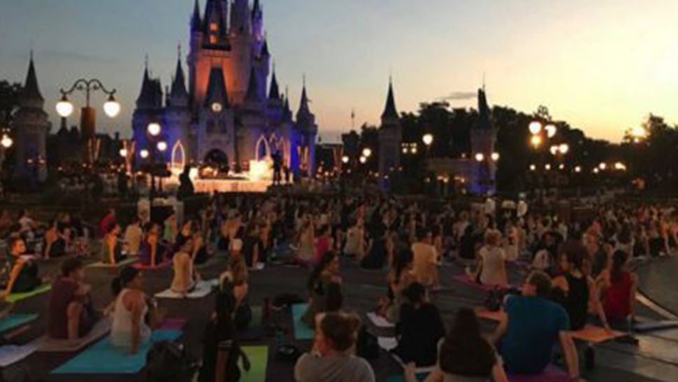 Disney World cast members participate in a morning yoga session in front of Cinderella Castle at Magic Kingdom. (Courtesy of Disney Parks)