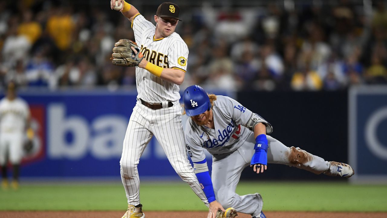 San Diego Padres second baseman Jake Cronenworth (9) gets the force out at second base on Los Angeles Dodgers' Justin Turner (10) during the fourth inning of a baseball game Tuesday, June 22, 2021, in San Diego. (AP Photo/Denis Poroy)