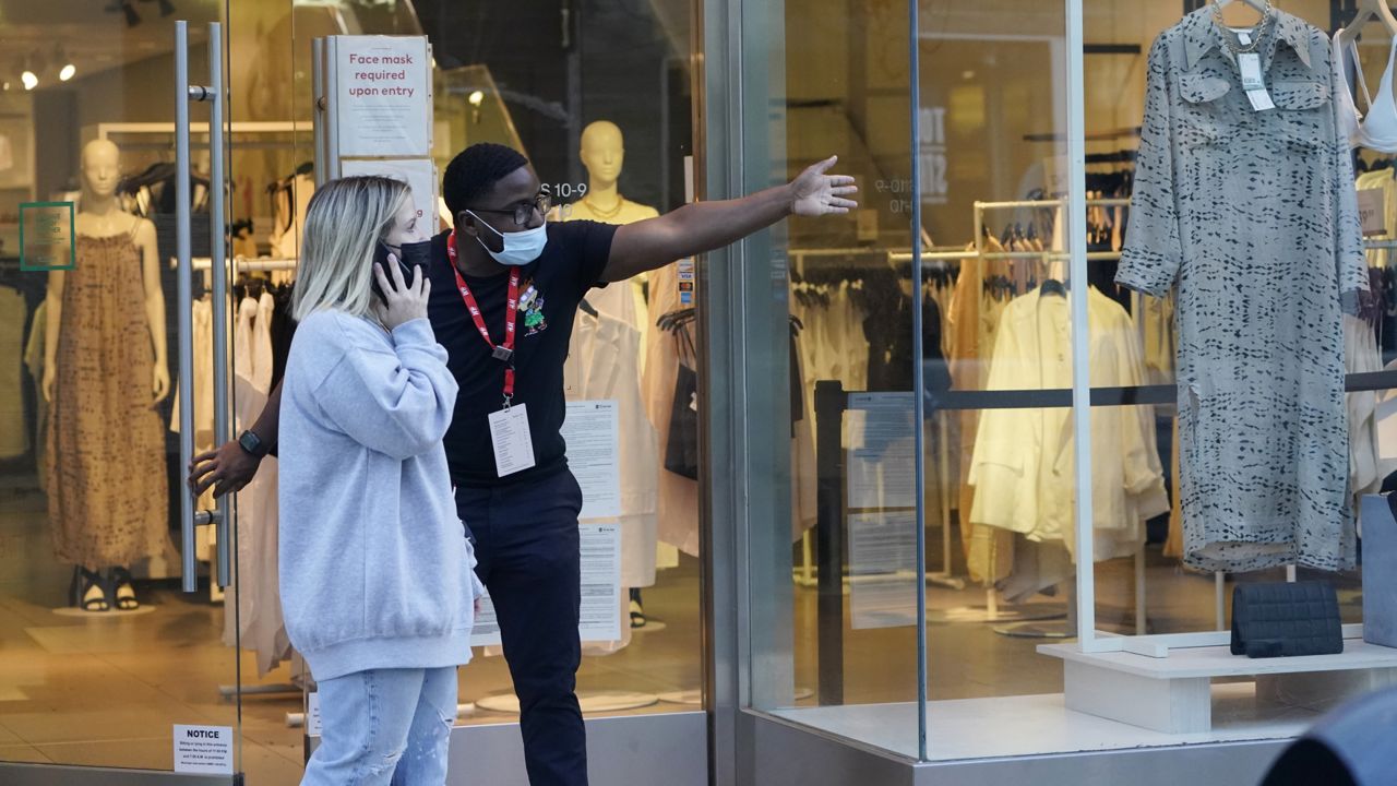 A salesperson gives directions to a shopper amid the COVID-19 pandemic on The Promenade Wednesday, June 9, 2021, in Santa Monica, Calif. (AP Photo/Marcio Jose Sanchez)