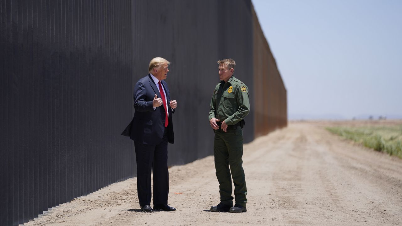 President Donald Trump speaks with Rodney Scott, the U.S. Border Patrol Chief, as he tours a section of the border wall, Tuesday, June 23, 2020, in San Luis, Ariz. (AP Photo/Evan Vucci)