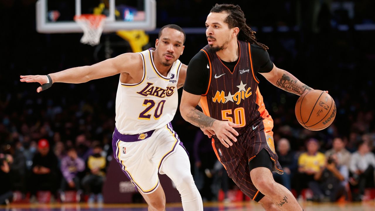 Orlando Magic guard Cole Anthony (50) drives past Los Angeles Lakers guard Avery Bradley (20) during the first half of an NBA basketball game in Los Angeles, Sunday, Dec. 12, 2021. (AP Photo/Ringo H.W. Chiu)