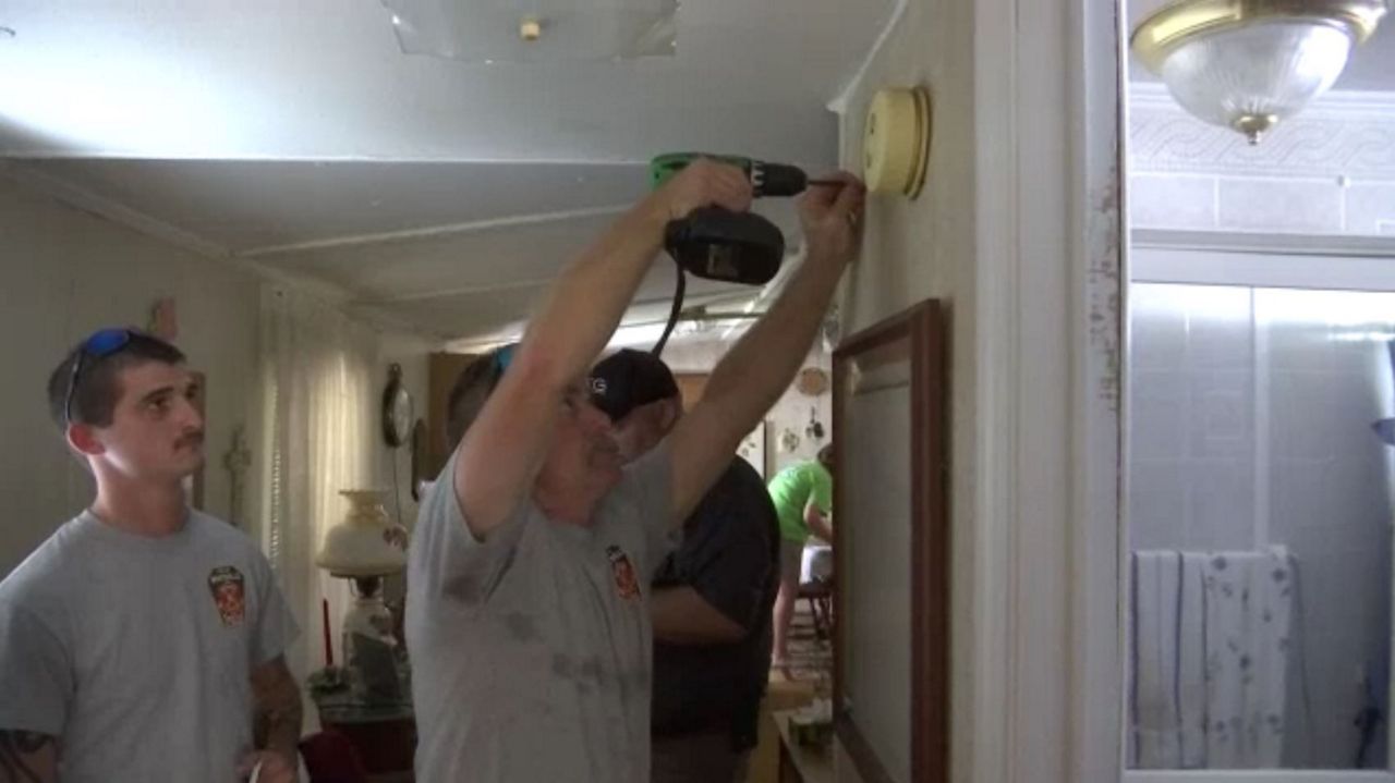 Volunteer fire fighters in Whiteville place a free smoke alarm in a home on Saturday. This state wide canvass was in response to the 91 fire fatalities that have happened in North Carolina this year.