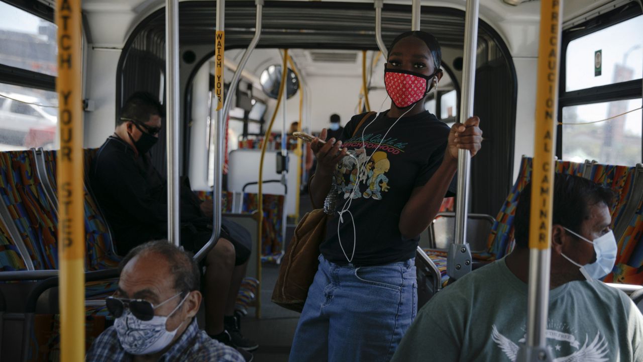 Commuters wearing masks ride a bus during the coronavirus pandemic in the Vermont Square neighborhood of Los Angeles, Thursday, May 21, 2020. (AP Photo/Jae C. Hong) 