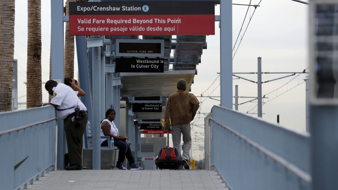 Uniformed fare checkers make sure passengers have paid their fare during dedication ceremonies for the Metro/LAX light rail transit line at Crenshaw and Exposition Boulevards in Los Angeles' Crenshaw district on Jan. 21, 2014. (AP Photo/Reed Saxon)
