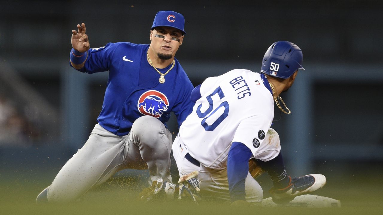 Chicago Cubs shortstop Javier Baez, left tags out Los Angeles Dodgers' Mookie Betts to complete a double play off an infield ground ball to fielder's choice by Max Muncy during the eighth inning of a baseball game in Los Angeles, Thursday, June 24, 2021. (AP Photo/Kelvin Kuo)