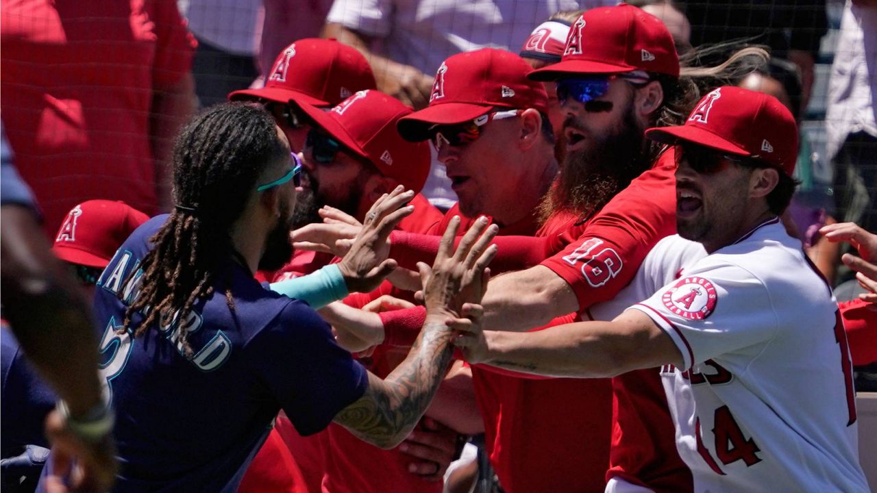 Seattle Mariners' J.P. Crawford, left, reacts after hitting a