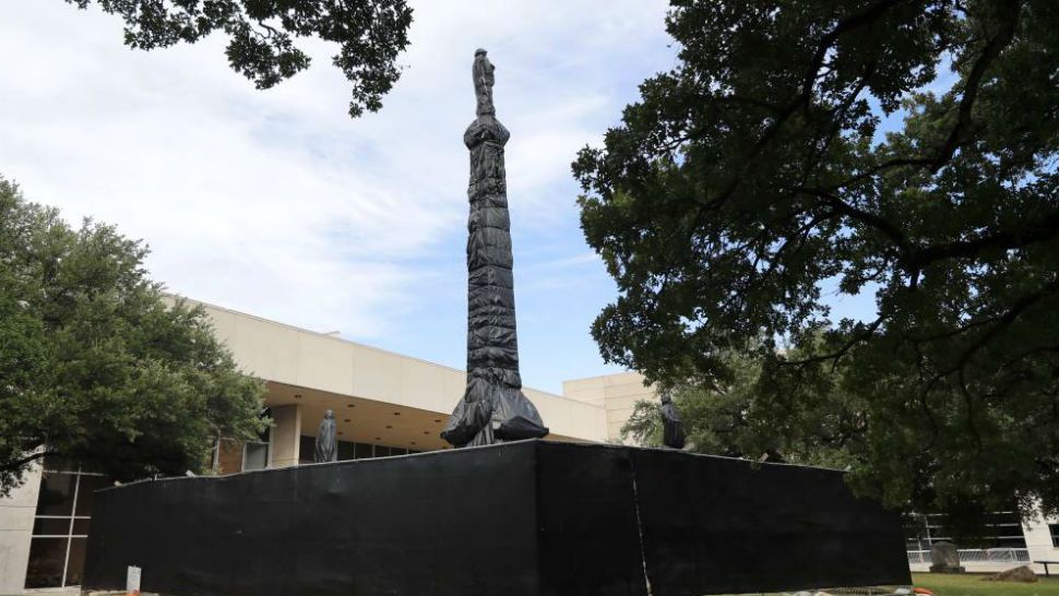 The Dallas Confederate War Memorial statue at Pioneer Park sits behind barricades, fencing and is covered in black plastic in Dallas, Friday, June 12, 2020. The obelisk statue, that is over 65-feet-tall, resides next door to the Kay Bailey Hutchison Convention Center and just blocks away from City Hall. The memorial depicts the scene of a Confederate soldier standing atop an obelisk surrounded by Confederate President Jefferson Davis and Gens. Robert E. Lee, Stonewall Jackson and Albert Sidney Johnston. City officials are currently considering whether the memorial should be removed. (AP Photo/Tony Gutierrez)