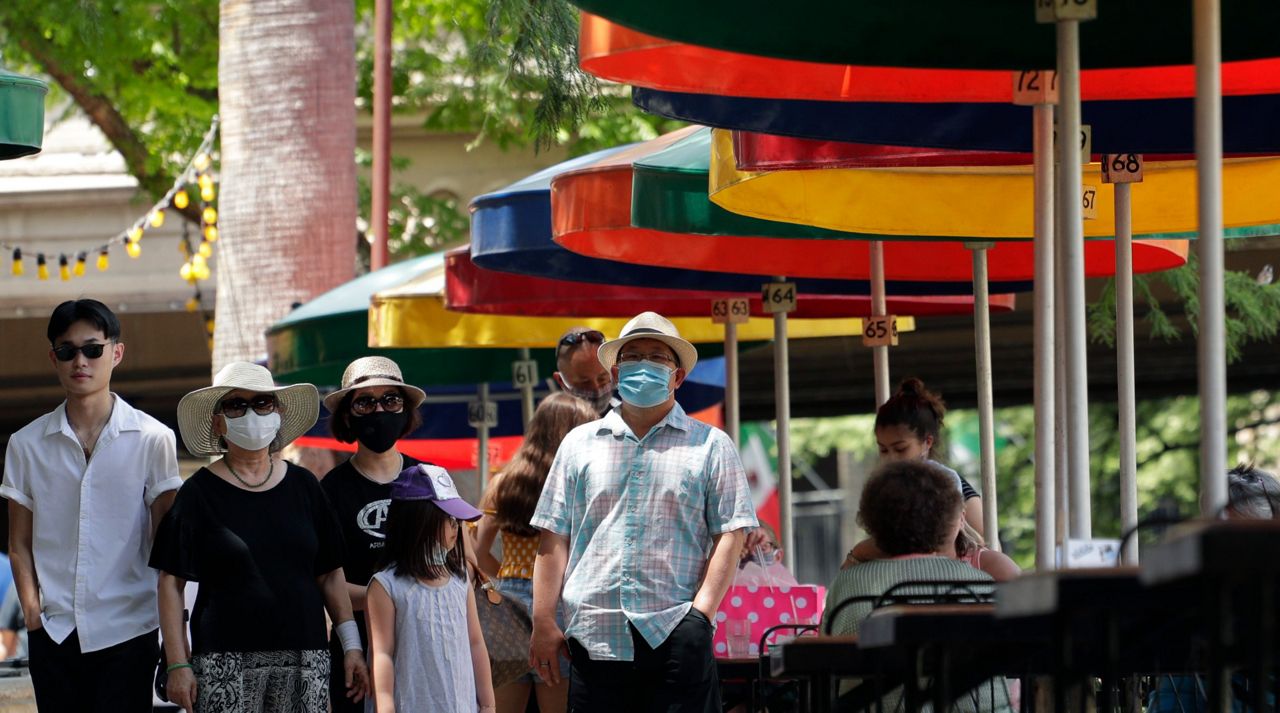Visitors, some wearing masks to protect against the spread of COVID-19, walk along the River Walk in San Antonio, Wednesday, June 24, 2020, in San Antonio.  (AP Photo/Eric Gay)