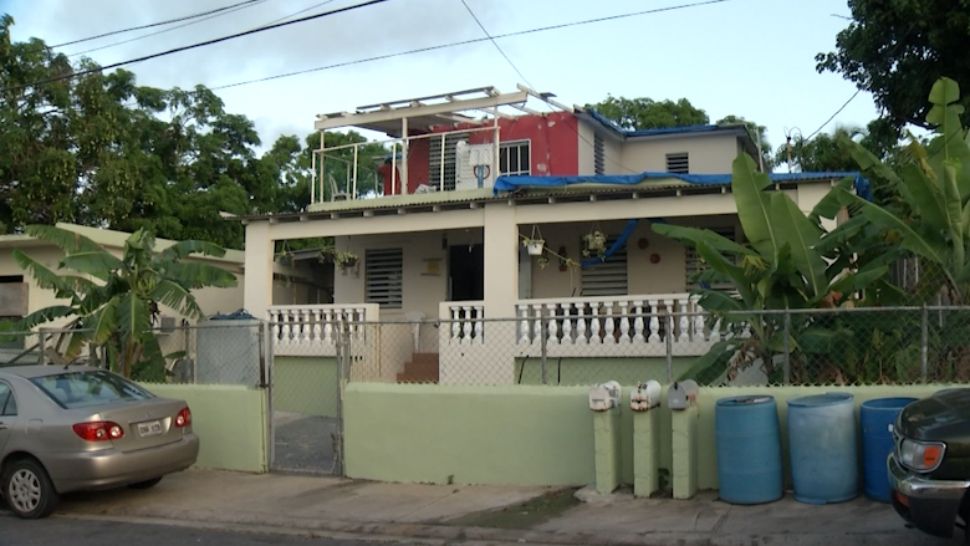 Homes like this one remain covered by a blue tarp, months after Hurricane Maria devastated the island. (Adria Iraheta, Spectrum News)