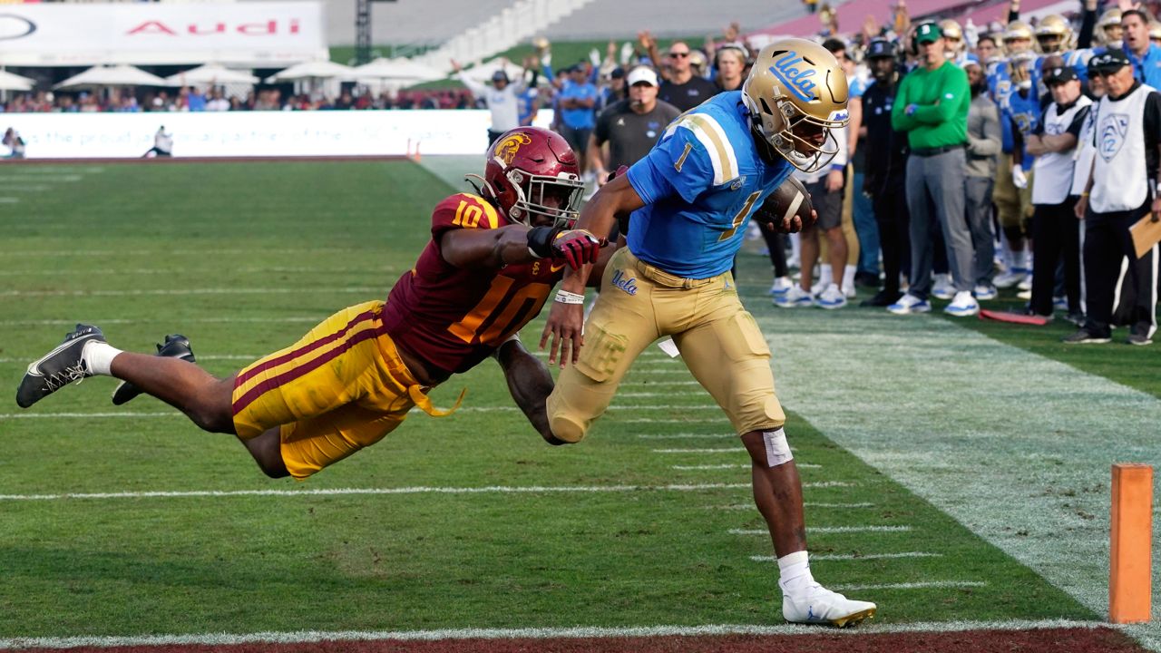 UCLA quarterback Dorian Thompson-Robinson, right, runs the ball in for a touchdown as Southern California linebacker Ralen Goforth defends during the first half of an NCAA college football game on Nov. 20, 2021, in Los Angeles. (AP Photo/Mark J. Terrill)