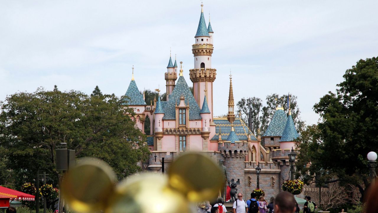 In this Jan. 22, 2015 file photo, visitors walk toward the Sleeping Beauty's Castle in the background at Disneyland Resort in Anaheim, Calif. (AP Photo/Jae C. Hong, File)