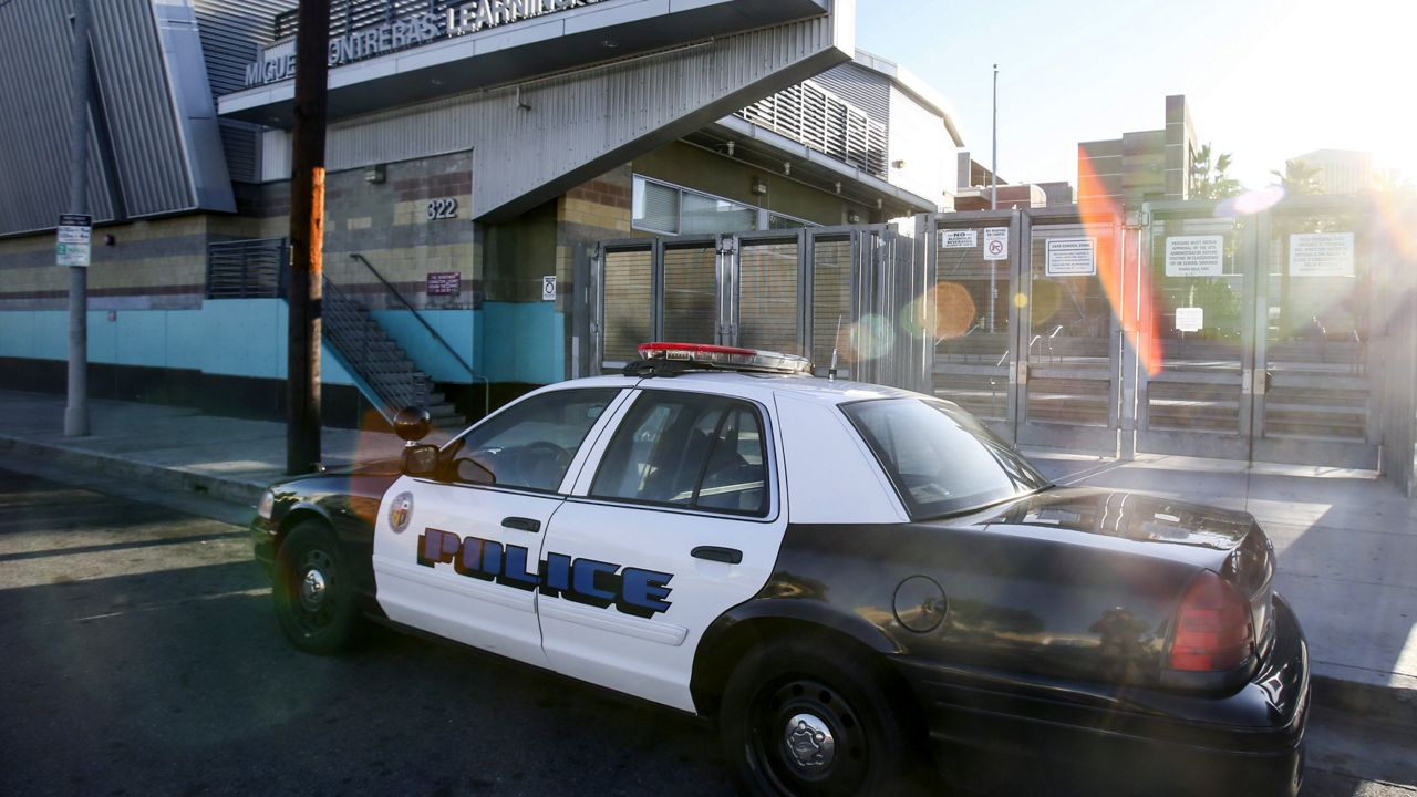 A police car is parked outside of Miguel Contreras Learning Complex in Los Angeles. (AP Photo/Ringo H.W. Chiu)