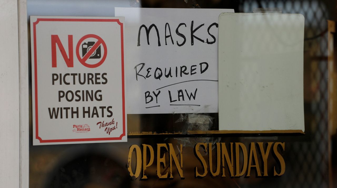A sign instructing shoppers to wear masks to protect against the spread of COVID-19 is posted at a business in San Antonio, Wednesday, June 24, 2020. Cases of COVID-19 have spiked in Texas and the governor is encouraging people to wear masks in public and stay home if possible. (AP Photo/Eric Gay)