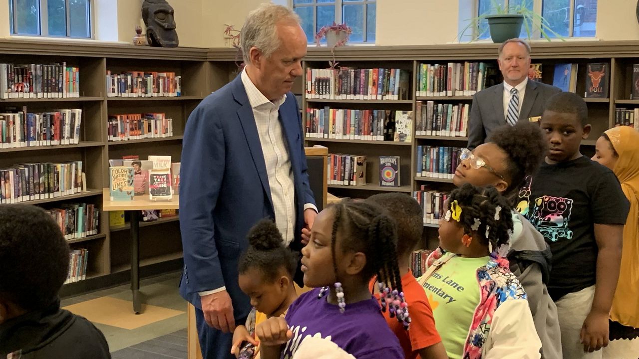 Mayor Greg Fischer and community members at a public library