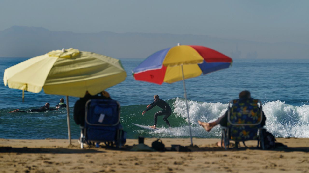Surfers in Huntington Beach, Calif. (AP Photo/Damian Dovarganes)