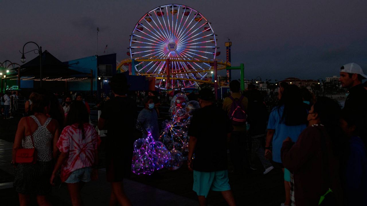 People stroll on the pier in Santa Monica, Calif., July 4, 2021. (AP Photo/Kyusung Gong)