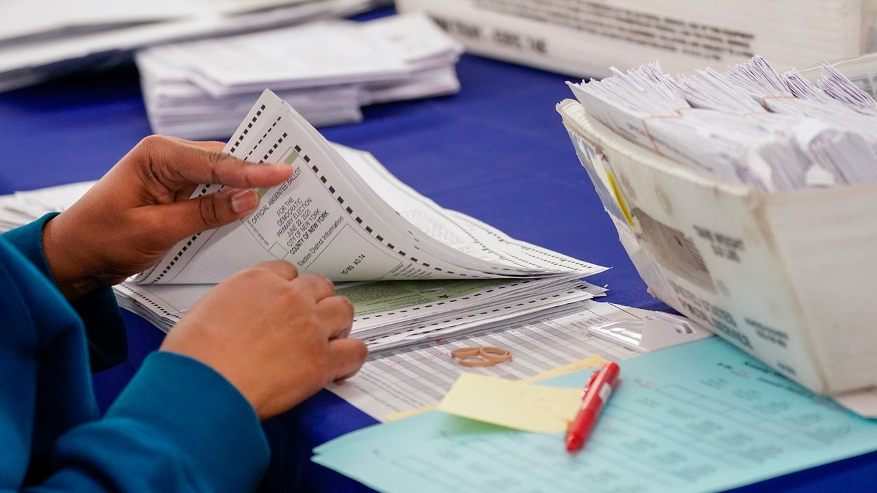 A person sorting absentee ballots (Provided: Associated Press)