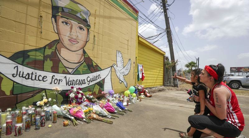 Dawn Gomez holds her 3-year-old granddaughter, Saryia Greer, who waves at Vanessa Guillen's mural painted by Alejandro "Donkeeboy" Roman Jr. on the side of Taqueria Del Sol, Thursday, July 2, 2020, in Houston. Army investigators believe Guillen, a Texas soldier missing since April, was killed by another soldier on the Texas base where they served, the attorney for the missing soldier's family said Thursday. (Steve Gonzales/Houston Chronicle via AP)