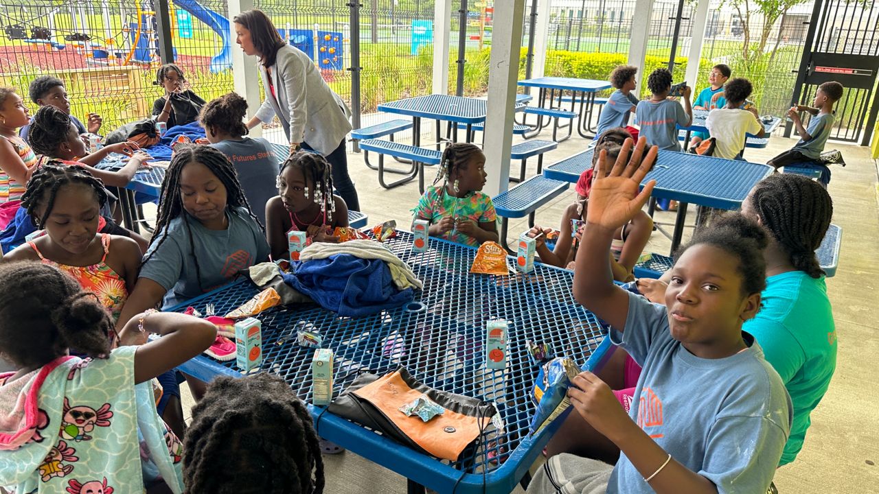 Students eat a snack after finishing their swimming lessons Thursday at the Boys and Girls Club of Central Florida location in Eatonville. (Spectrum News/Jordan Mead)