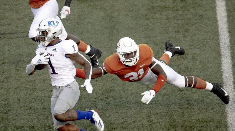 In this Oct. 19, 2019, file photo, Texas' DeMarvion Overshown (31) leaps to tackle Kansas running back Pooka Williams Jr. (1) during an NCAA college football game in Austin, Texas. (Nick Wagner/Austin American-Statesman via AP, File) 