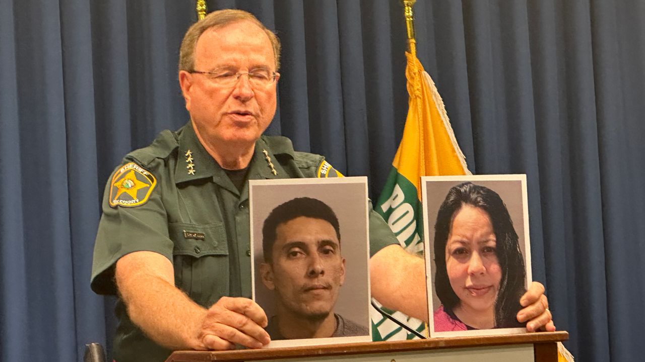 Polk County Sheriff Grady Judd shows photos of the suspects, Joel and Jazmine Rondon. (Trevor Pettiford/Spectrum Bay News 9)