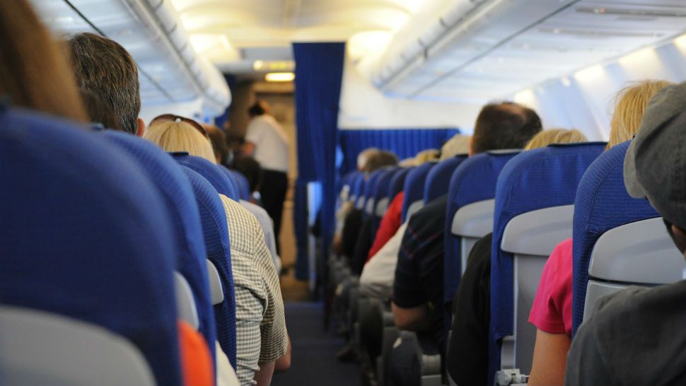 FILE - People in plane seats during a flight. 