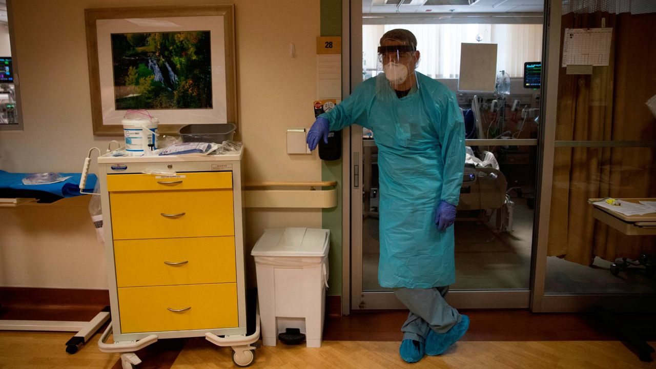 Nurse Spencer Cushing, 29, pauses briefly after tending to a COVID-19 patient at St. Jude Medical Center in Fullerton, Calif., July 7, 2020. (AP Photo/Jae C. Hong)