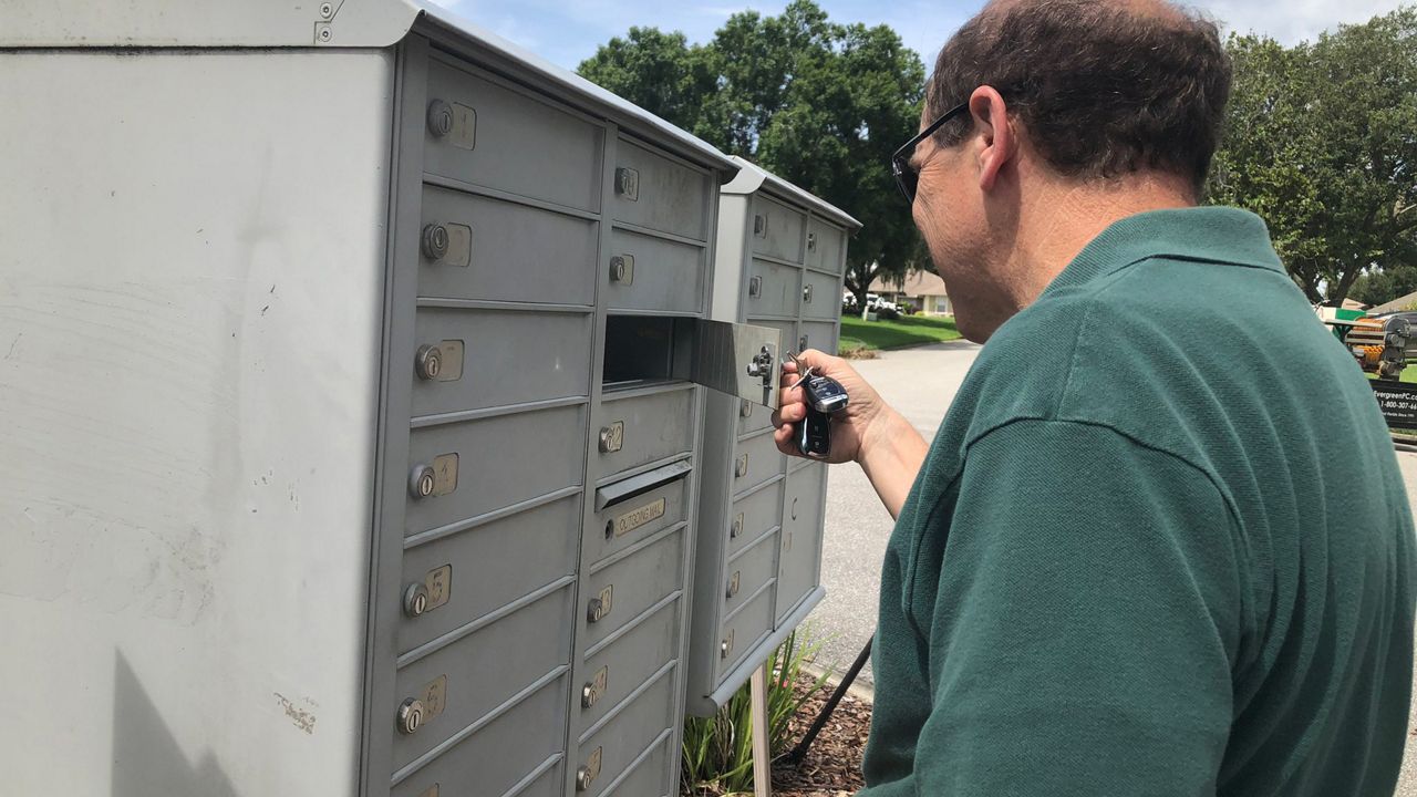 Michael Pagano, who says he's a victim of identity theft, looks into an opened mail box. (Spectrum News/Stephanie Coueignoux)