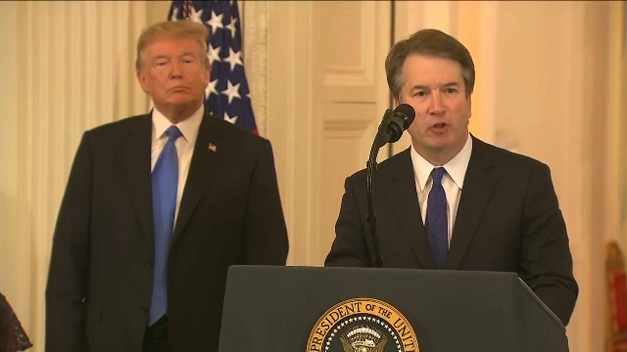 President Donald Trump behind Brett Kavanaugh.