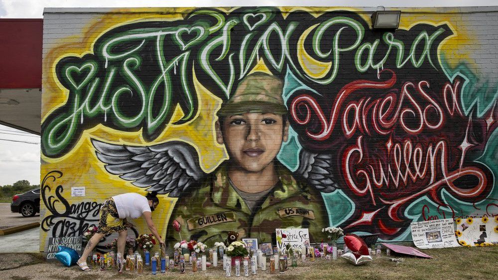 Veronica Carbajal places a candle at a mural for Army Spc. Vanessa Guillen in Austin, Texas, on Monday July 6, 2020. Guillen went missing from Fort Hood in April, and is believed to have been killed by another soldier. The mural was created Saturday and Sunday by artists Fili Mendieta and Arturo Silva. (Jay Janner/Austin American-Statesman via AP)