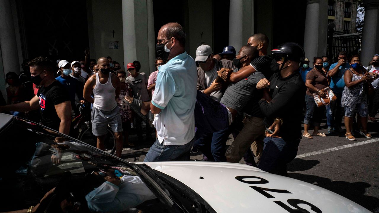 Police detain an anti-government demonstrator during a protest in Havana, Cuba, Sunday July 11, 2021. Hundreds of demonstrators went out to the streets in several cities in Cuba to protest against ongoing food shortages and high prices of foodstuffs, amid the new coronavirus crisis. (AP Photo/Ramon Espinosa)