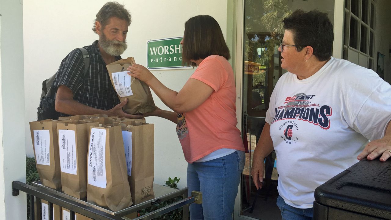 Volunteers at Community Congregational Church in New Port Richey hand out a free bagged lunch as part of the "Love A Lunch" Program. (Sarah Blazonis, Staff)