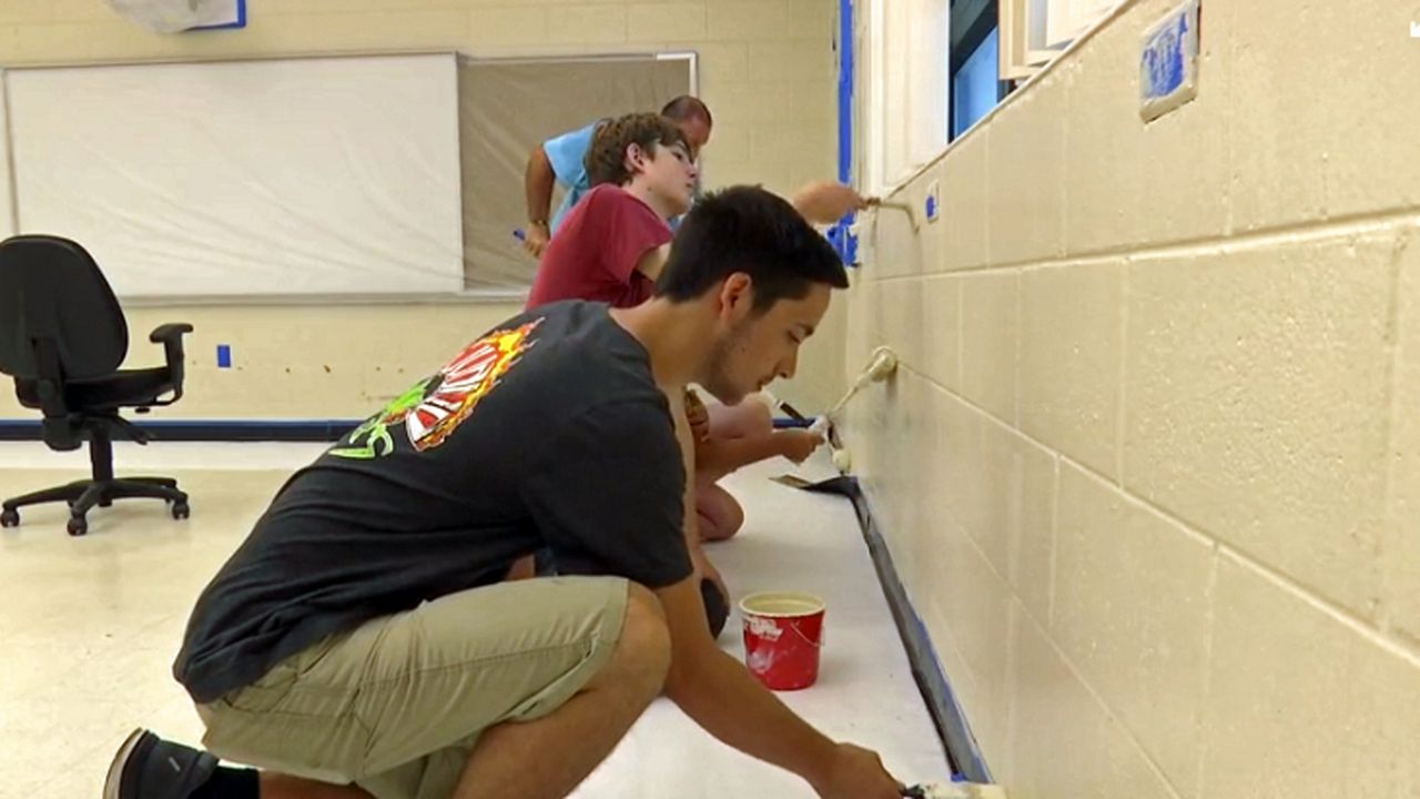For over a week and going into their second week, dozens of volunteers from different groups and Habitat for Humanity are giving a Title I school a new paint job. (Krystel Knowles, staff)