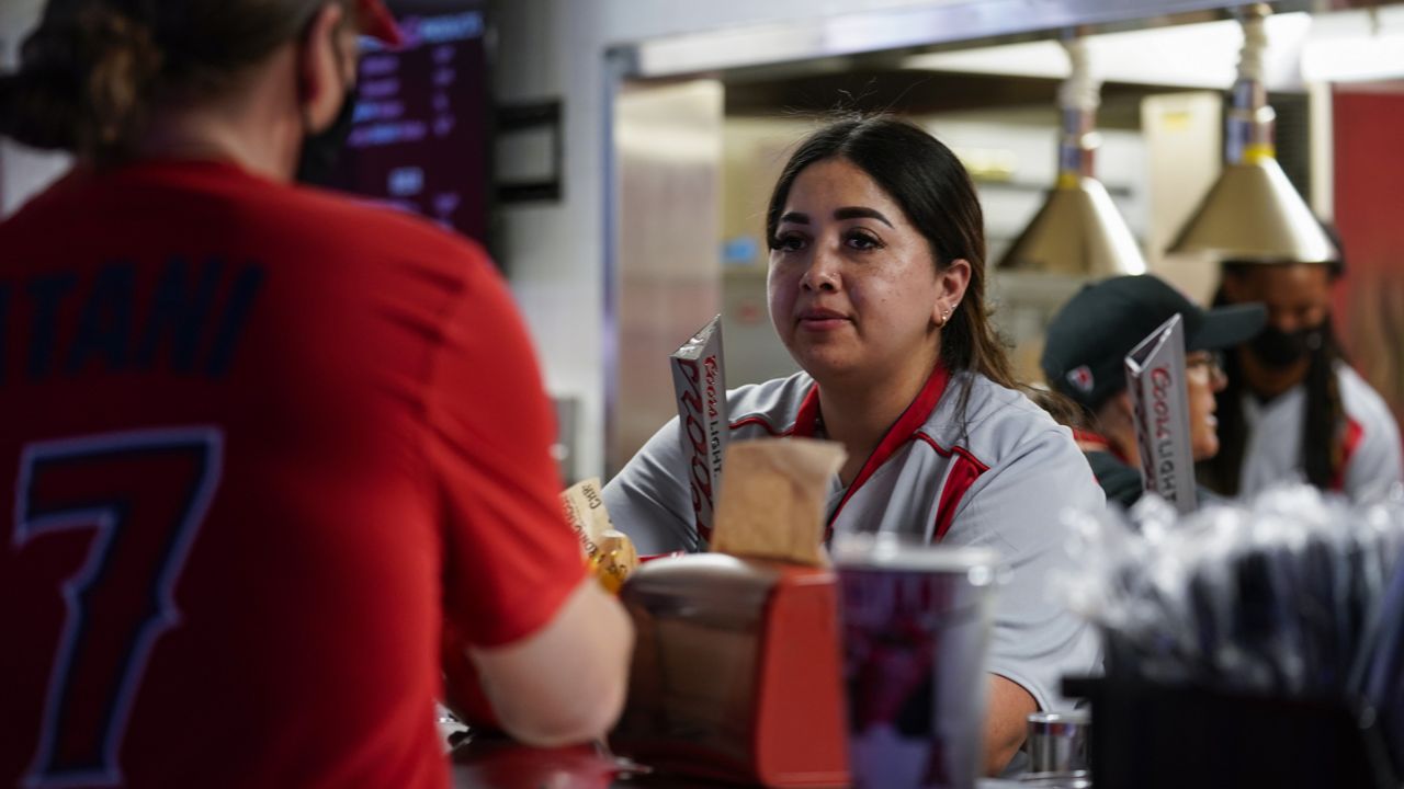 An employee of Angel Stadium serves a customer before a baseball game between the Boston Red Sox and the Los Angeles Angels Monday, July 5, 2021, in Anaheim, Calif. (AP Photo/Ashley Landis)