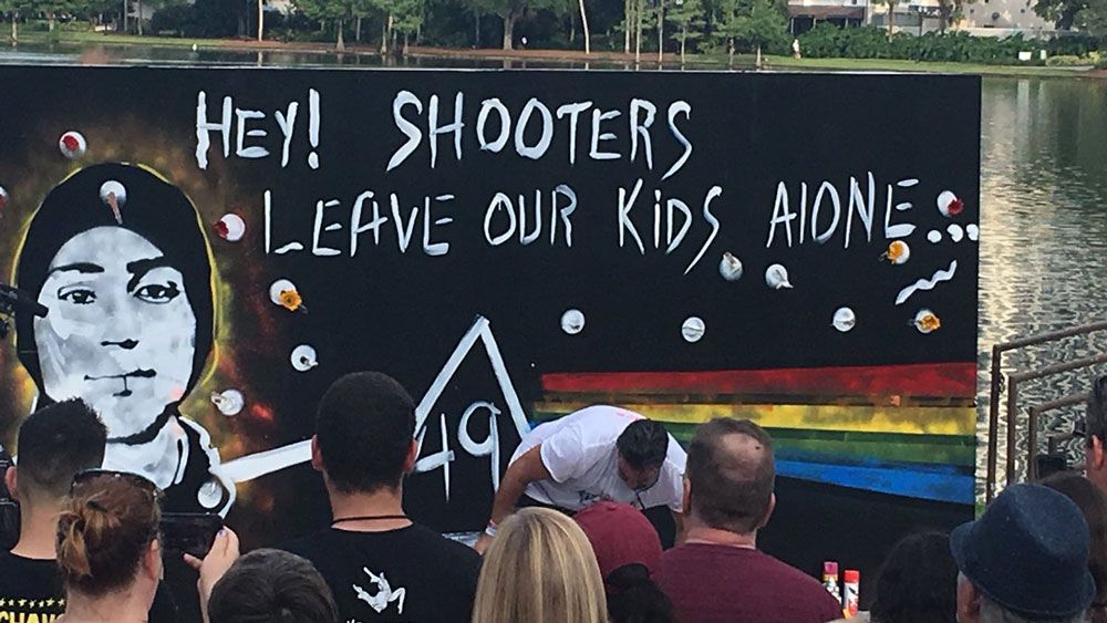 The father of one of the Parkland shooting victims paints a mural at the March for Our Lives rally in Orlando Friday. (Bailey Myers, Staff)