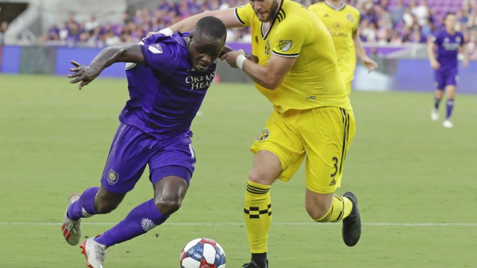 Columbus Crew's Josh Williams (3) grabs Orlando City's Benji Michel, left, by his jersey in an attempt to slow him down during the first half of an MLS soccer match Saturday, July 13, 2019, in Orlando, Fla. (AP Photo/John Raoux)