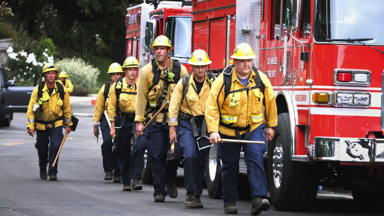 Firefighters walk in line to fight the wildfire in the Pacific Palisades area of Los Angeles, Sunday, May 16, 2021. (AP Photo/Ringo H.W. Chiu)