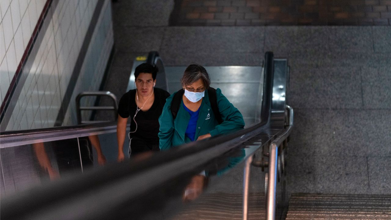 Two commuters ride an escalator as they exit a Metro station in Los Angeles, Wednesday, July 13, 2022. (AP Photo/Jae C. Hong)